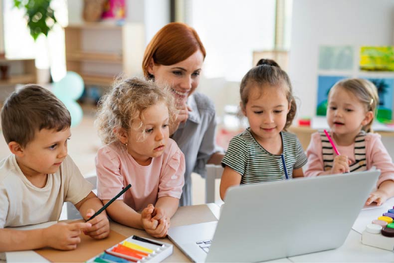 Teacher with children in front of a laptop